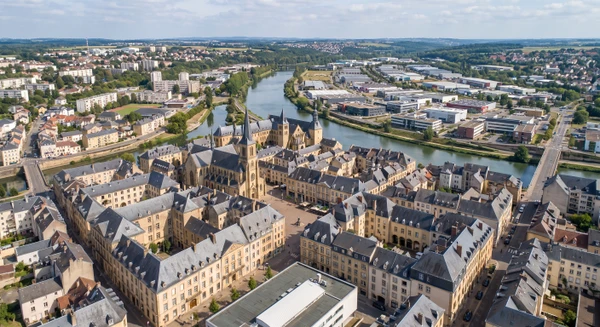 Photographie aérienne ou vue panoramique du paysage urbain de Thionville en Moselle, montrant les caractéristiques architecturales et urbaines distinctives de la ville (centre-ville, zones résidentielles ou commerciales, paysage urbain typique), capturée en lumière naturelle claire, sans texte ni logo, avec une perspective professionnelle adaptée à un site d'électricien-installateur de sécurité.